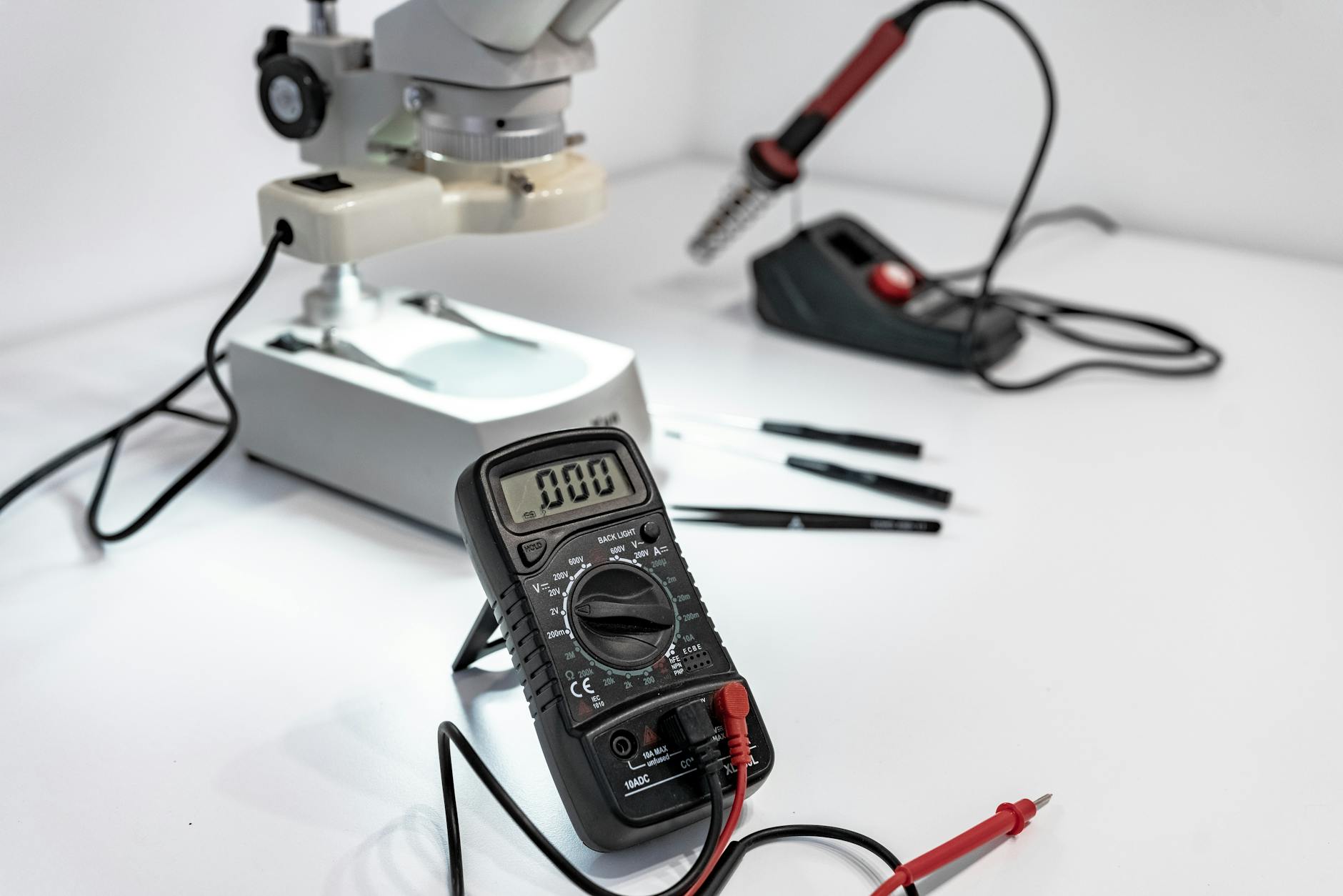Stół serwisowy z multimetrem, mikroskopem i lutownicą do diagnostyki elektroniki