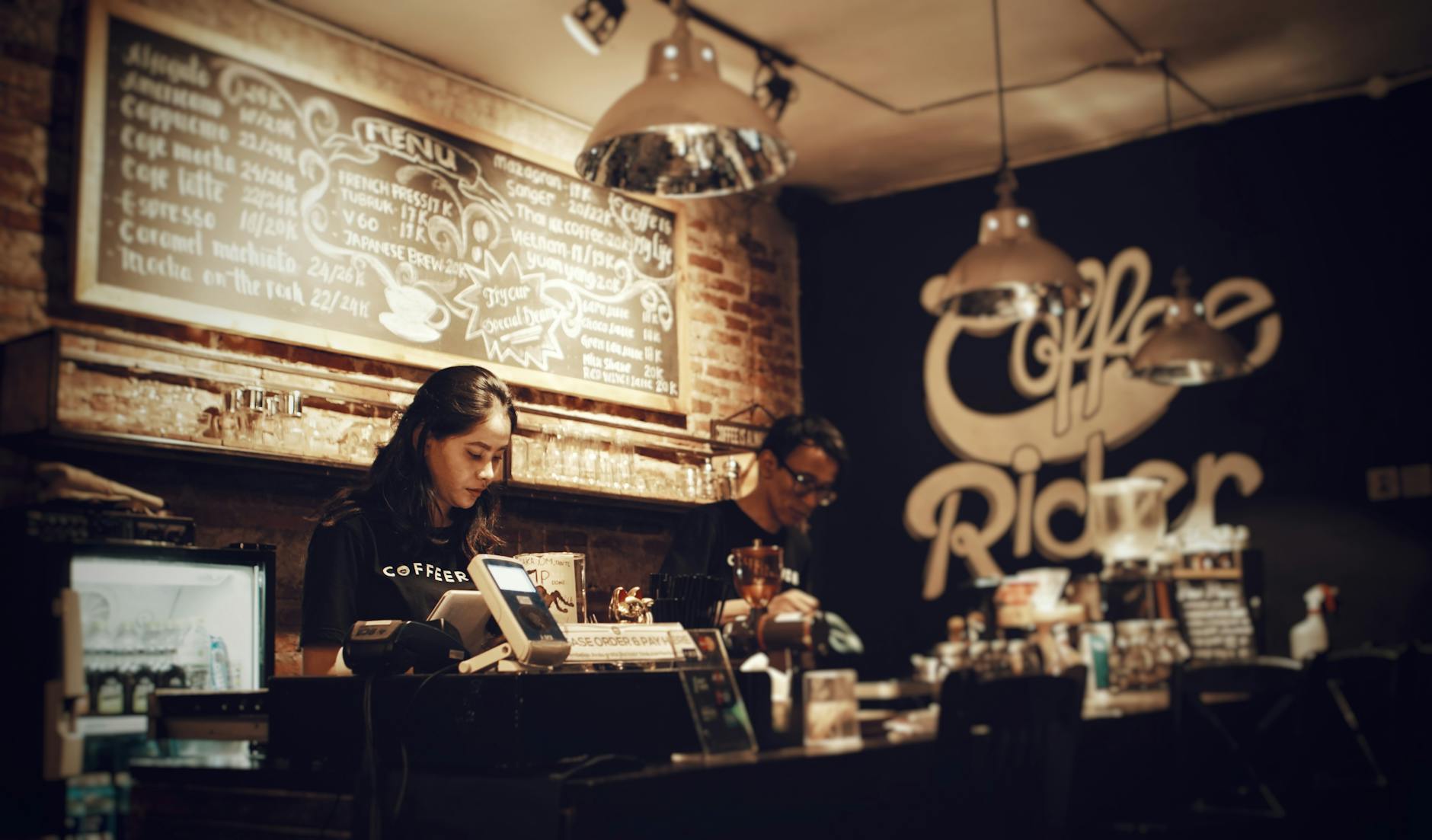 Bariści przygotowują kawę w przytulnej kawiarni Coffee Rider
