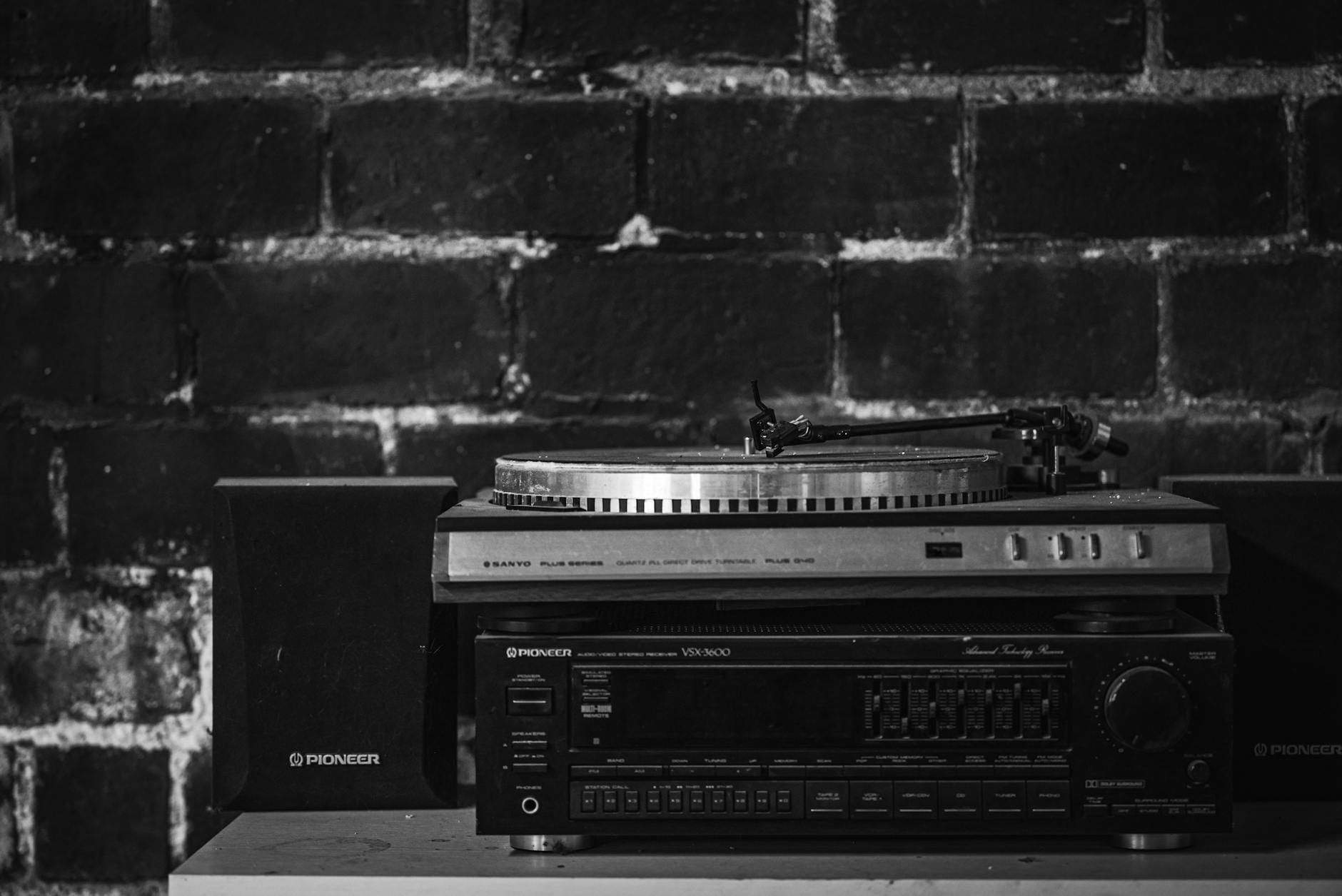 Czarno-białe stereo z gramofonem i kolumnami przy ceglanej ścianie