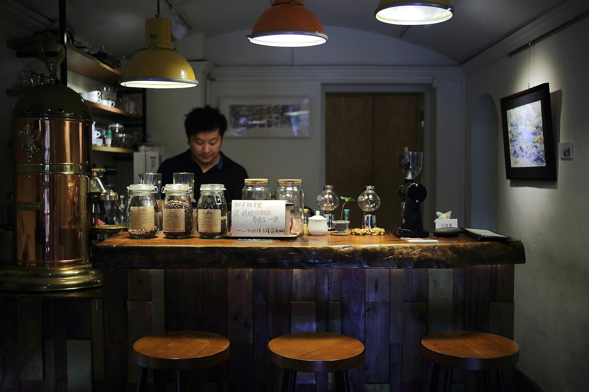 Przytulna kawiarnia z baristą przygotowującym kawę za ladą