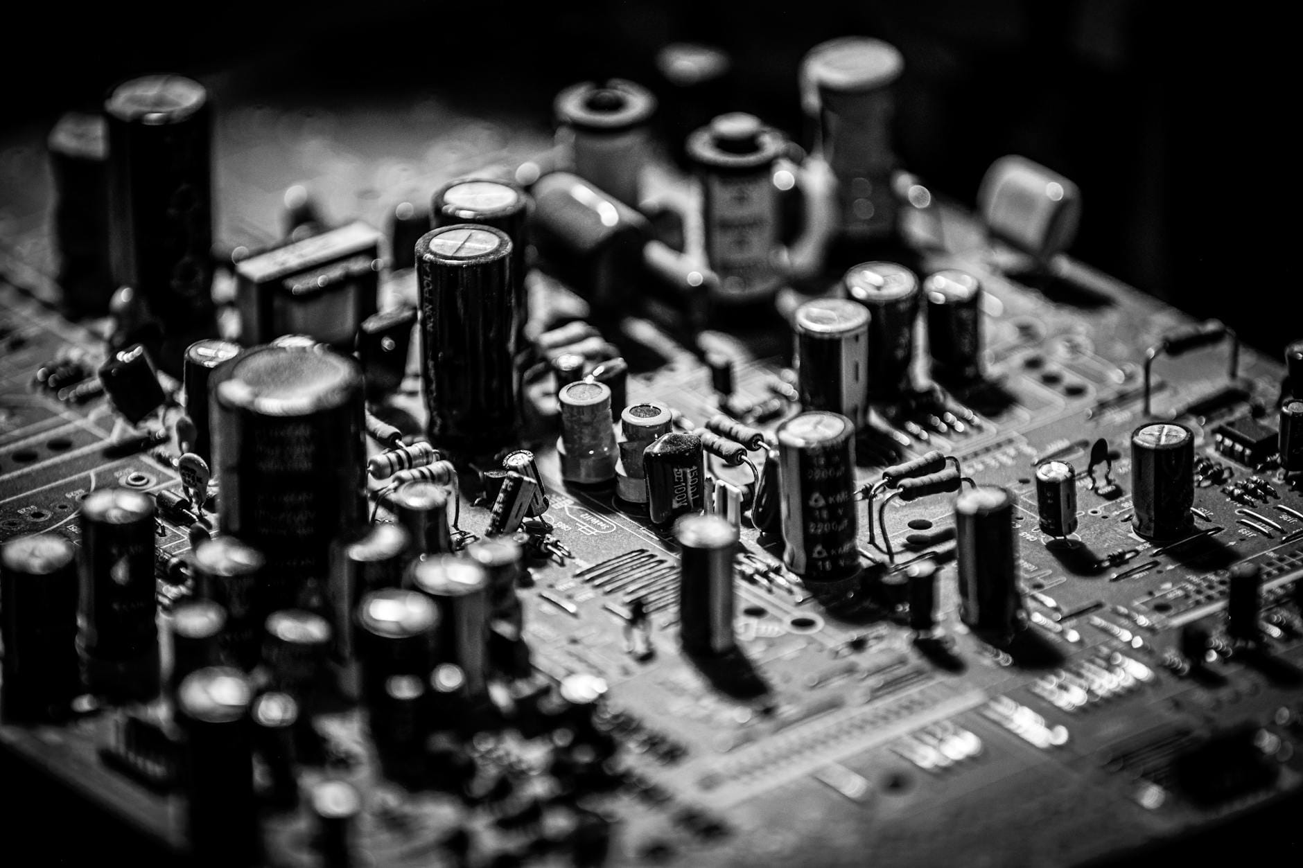 Czarno-białe zbliżenie płytki elektronicznej z kondensatorami i tranzystorami