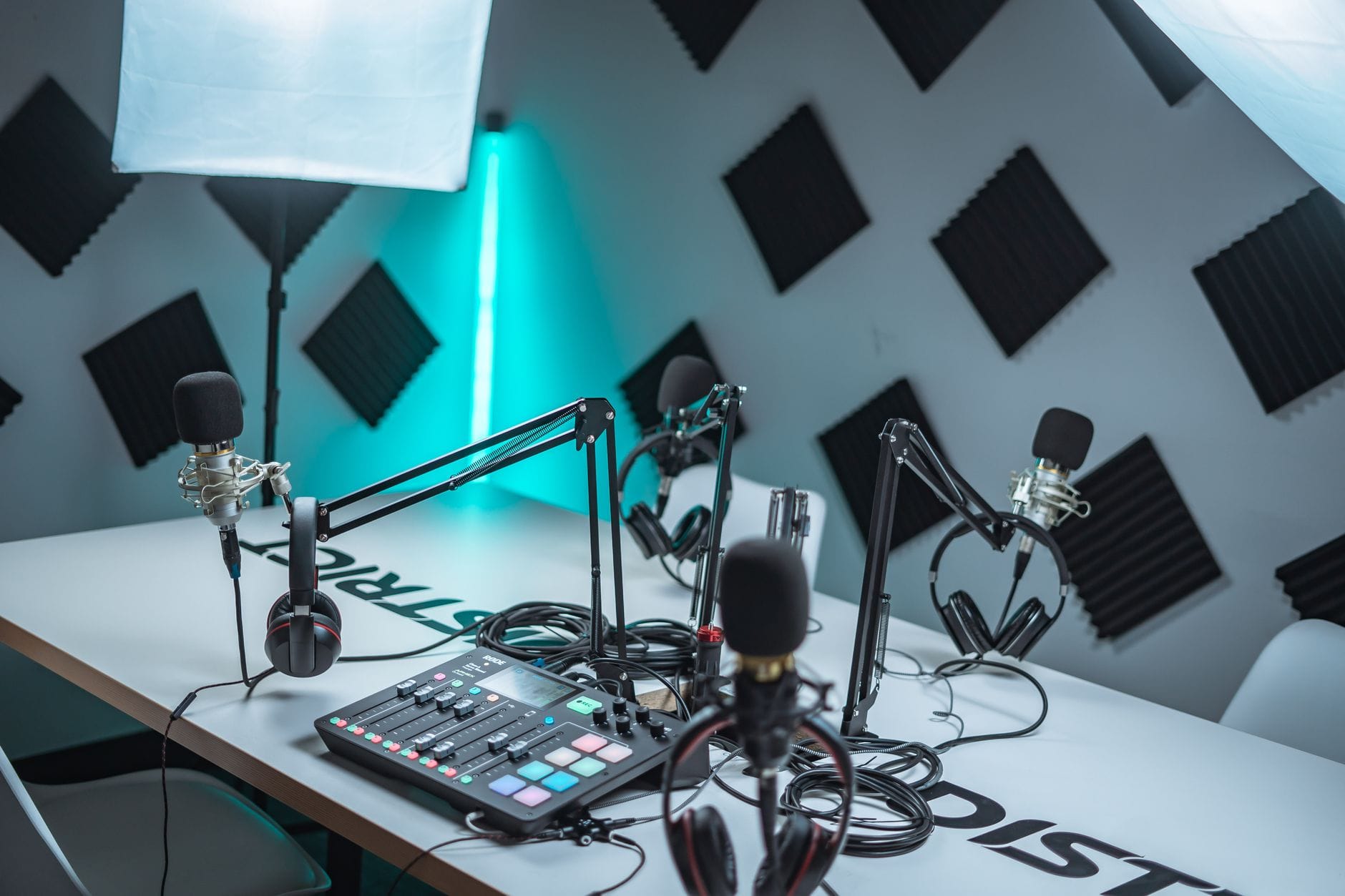 Nowoczesne studio podcastowe z mikrofonami, mikserem i panelami akustycznymi