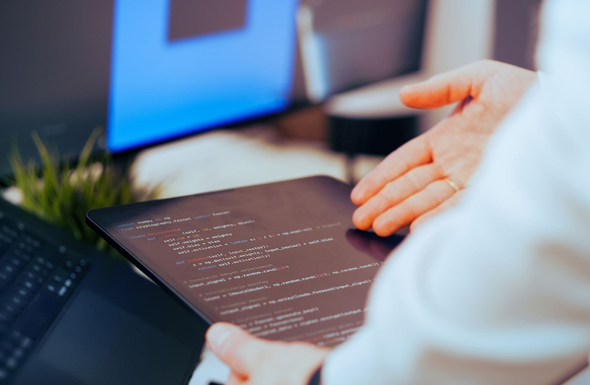 Praktyczne zastosowania AI w małych firmach: jak bezpiecznie wdrożyć sztuczną inteligencję w codziennej pracy Programista analizuje kod na tablecie w nowoczesnym biurze