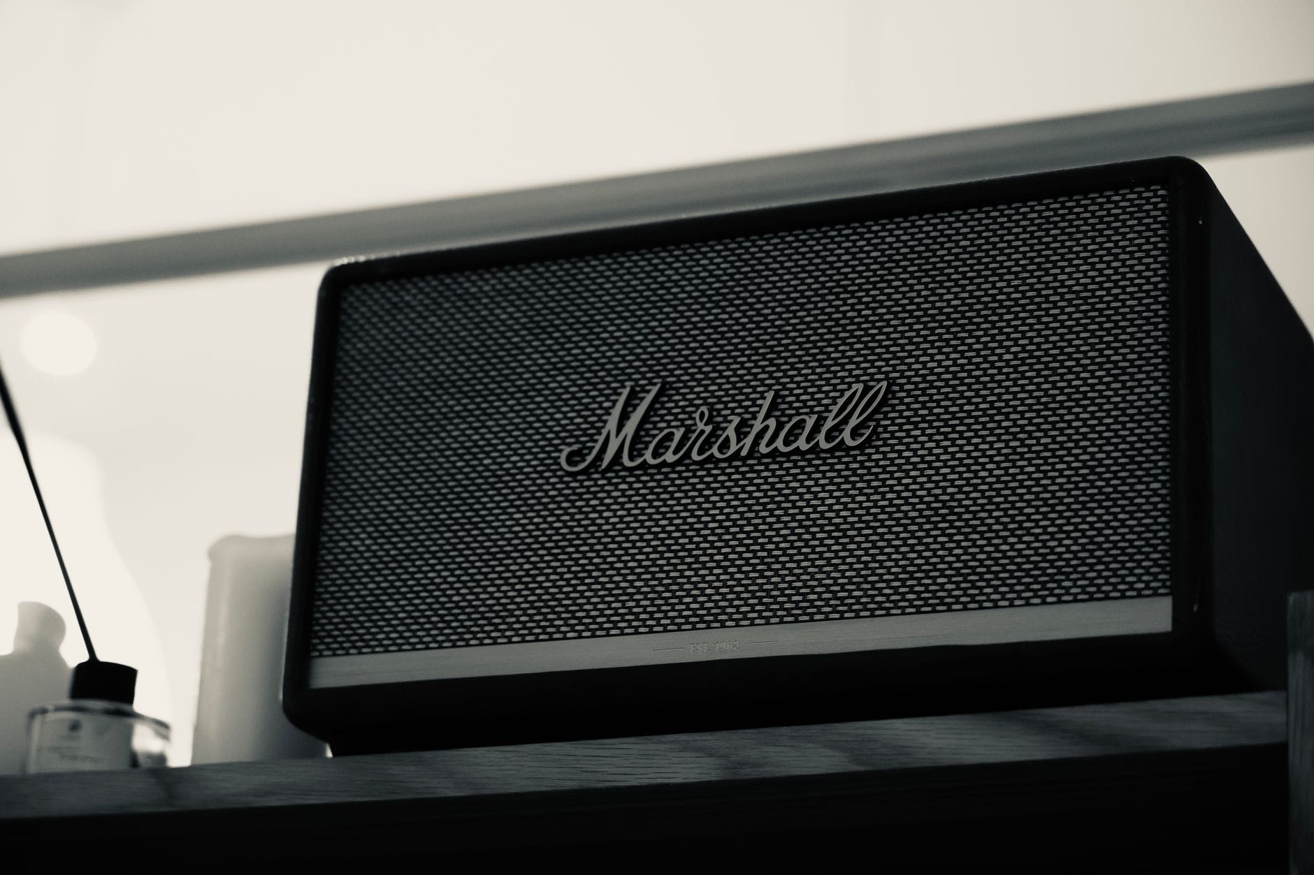 Czarny głośnik Marshall Bluetooth na drewnianej półce
